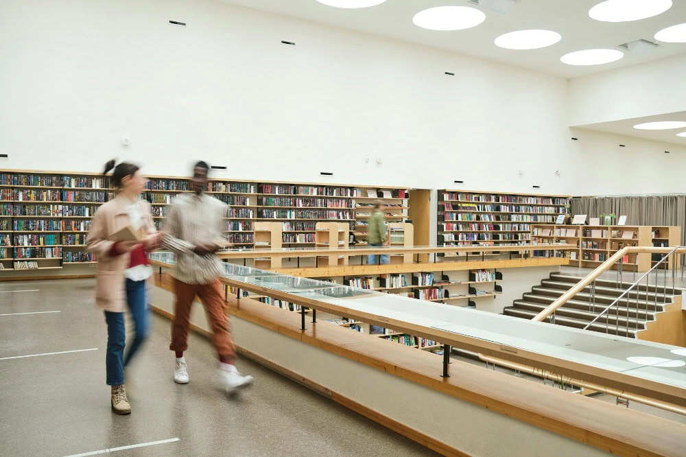 Two people walking in a library