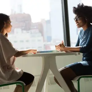 two women having a discussion at a table